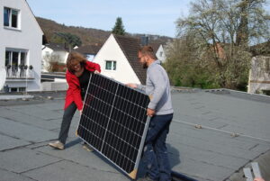 Annette Unkelbach und Mitarbeiter der Stadtwerke mit Solarmodul